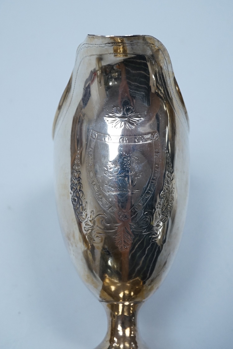 A George III silver cream jug, of oval form, London, 1801, 11cm, a George III silver helmet shaped cream jug, London, 1793, a George III small silver sugar pail, London, 1799 and a George V silver 'whisky' label, 8.4oz.